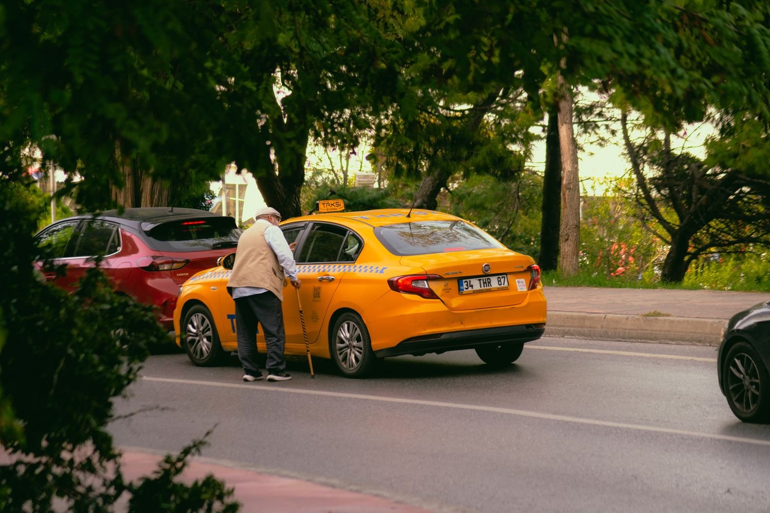 Yellow taxi picking up a rider on a city street